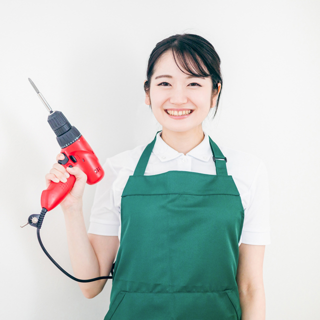 電動ドライバーを持つ女性